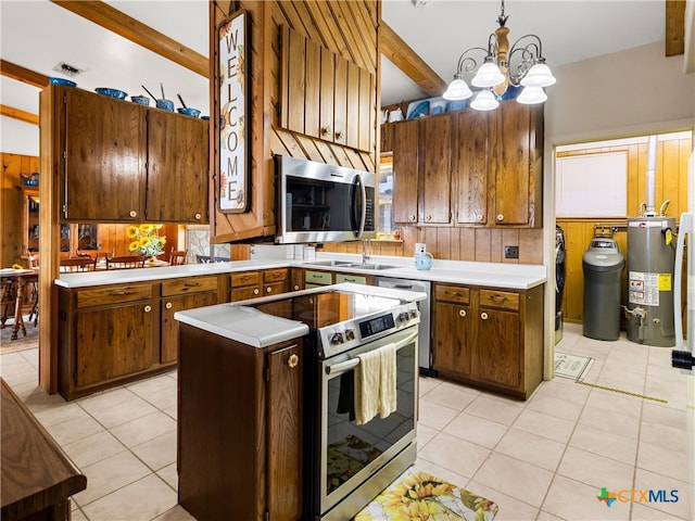 kitchen featuring sink, decorative light fixtures, appliances with stainless steel finishes, a kitchen island, and water heater