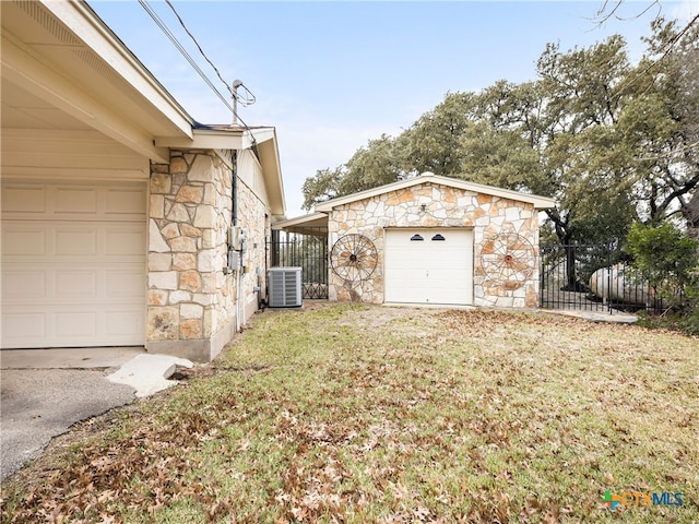 exterior space with a garage, an outdoor structure, and central AC