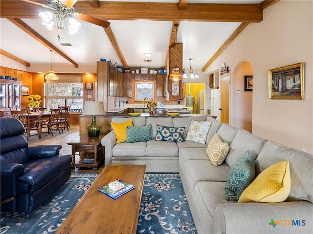 living room with vaulted ceiling with beams, sink, dark tile patterned flooring, and ceiling fan