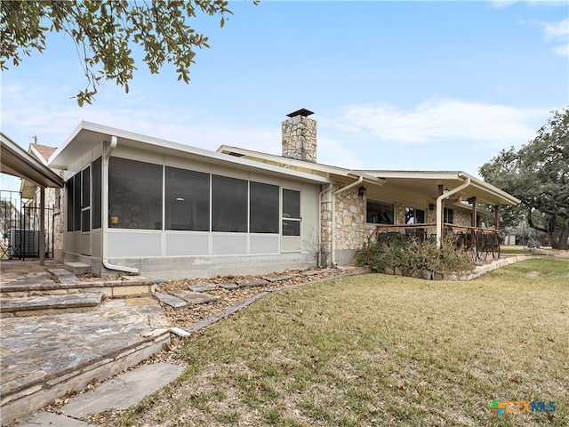 back of property with a yard and a sunroom