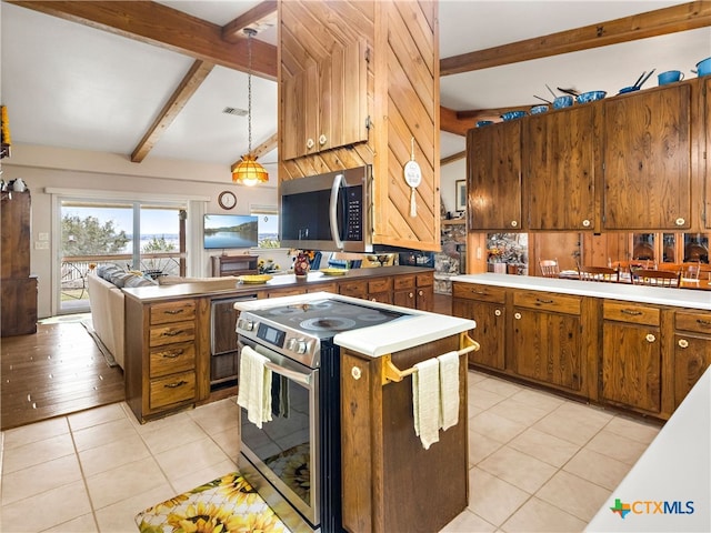 kitchen featuring light tile patterned flooring, appliances with stainless steel finishes, lofted ceiling with beams, and hanging light fixtures