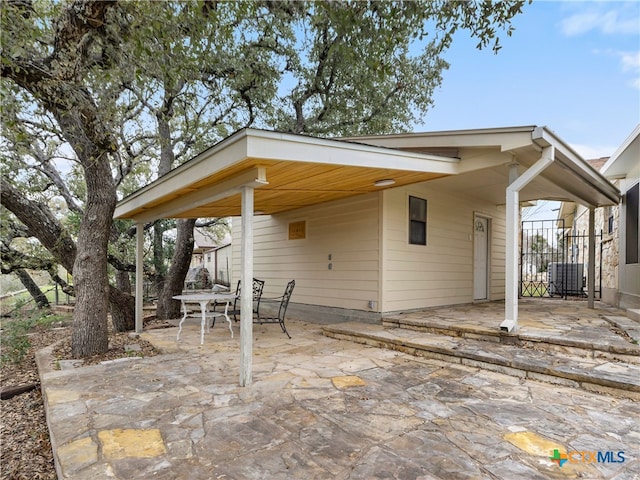 view of patio / terrace with cooling unit and a carport