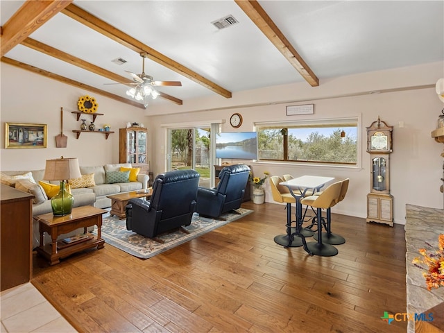 living room featuring ceiling fan, hardwood / wood-style floors, and vaulted ceiling with beams