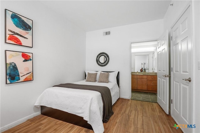 2502 Leon St Unit 201, Austin, TX 78705 - bedroom with baseboards, visible vents, light wood finished floors, and ensuite bath