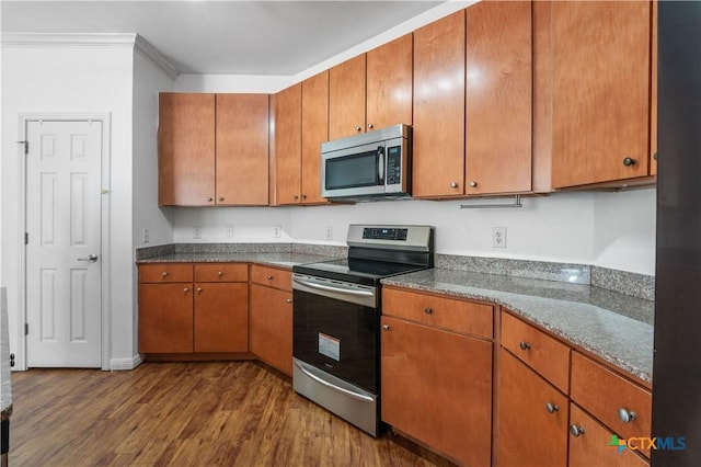 2502 Leon St Unit 201, Austin, TX 78705 - kitchen featuring crown molding, stainless steel appliances, brown cabinets, and dark wood finished floors
