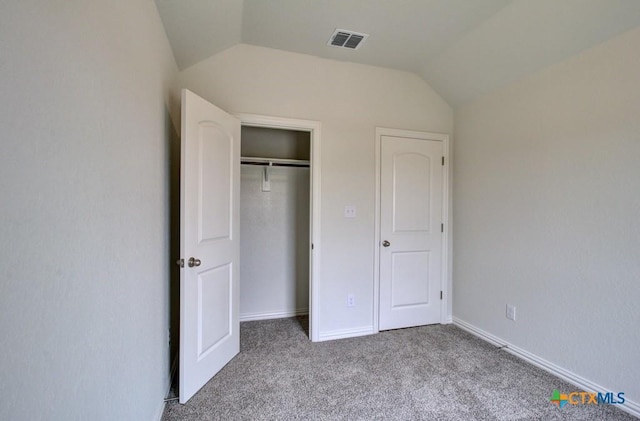 unfurnished bedroom with lofted ceiling, carpet, baseboards, visible vents, and a closet