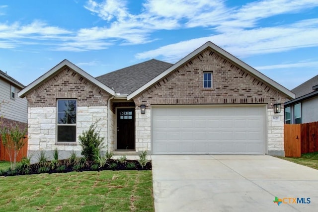 single story home featuring stone siding, driveway, fence, and an attached garage