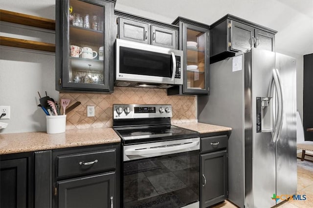 2903 Tucson Dr, Killeen, TX 76543 - kitchen with stainless steel appliances, decorative backsplash, glass insert cabinets, and light stone counters