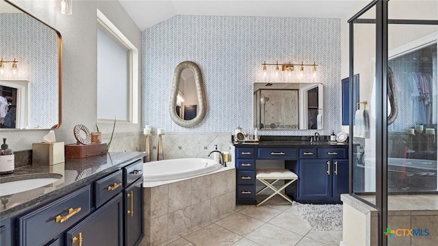 full bath with tile patterned floors, a garden tub, lofted ceiling, two vanities, and a shower stall
