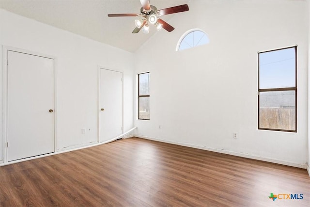 unfurnished bedroom featuring hardwood / wood-style floors, high vaulted ceiling, and ceiling fan