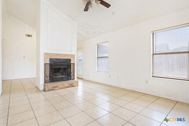 unfurnished living room featuring ceiling fan, light tile patterned floors, a textured ceiling, and vaulted ceiling