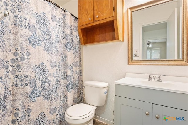 bathroom featuring vanity, toilet, ceiling fan, and curtained shower