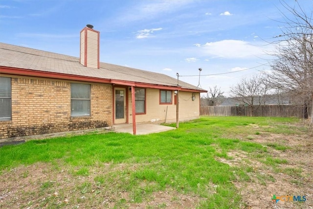 rear view of house with a yard and a patio