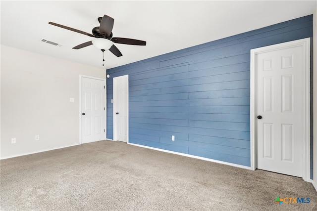 carpeted spare room featuring ceiling fan