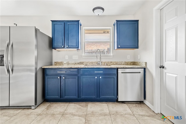 kitchen with sink, blue cabinets, and appliances with stainless steel finishes