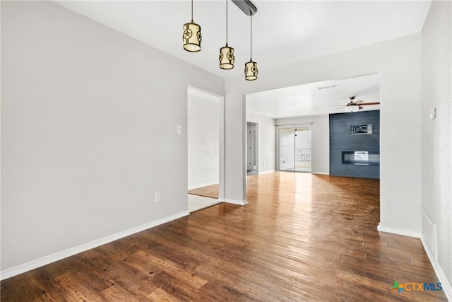 interior space featuring a fireplace, wood-type flooring, and ceiling fan