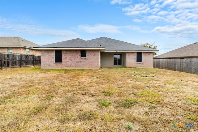 rear view of property with a yard