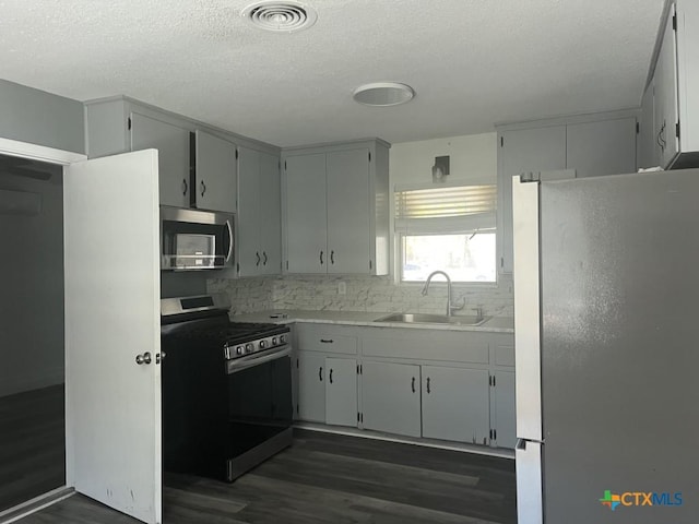 kitchen with backsplash, dark hardwood / wood-style floors, sink, and appliances with stainless steel finishes