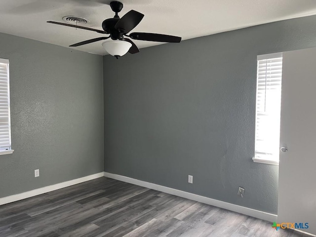 empty room with hardwood / wood-style floors, ceiling fan, and a healthy amount of sunlight