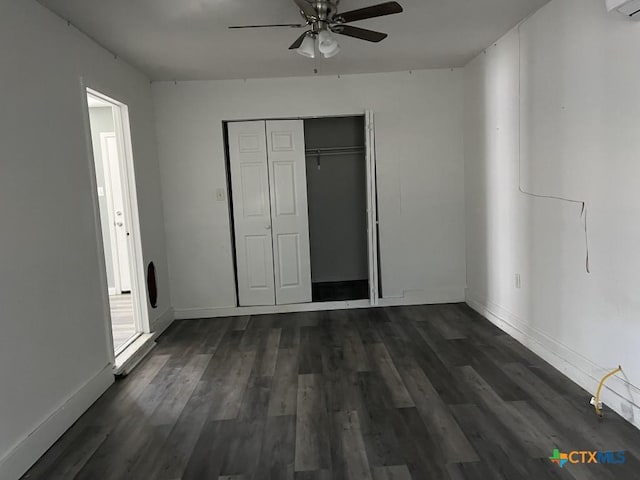 unfurnished bedroom with ceiling fan, dark wood-type flooring, and a closet