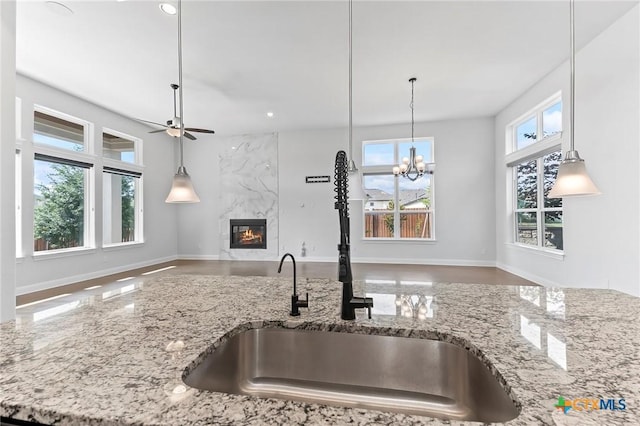 4201 Arques Ave, Round Rock, TX 78681 - kitchen featuring a sink, open floor plan, a fireplace, light stone countertops, and recessed lighting