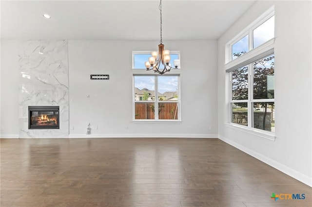 4201 Arques Ave, Round Rock, TX 78681 - unfurnished dining area with a chandelier, a fireplace, dark wood-type flooring, baseboards, and recessed lighting