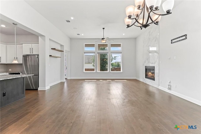 4201 Arques Ave, Round Rock, TX 78681 - unfurnished living room featuring a ceiling fan, a high end fireplace, dark wood-type flooring, a chandelier, and recessed lighting