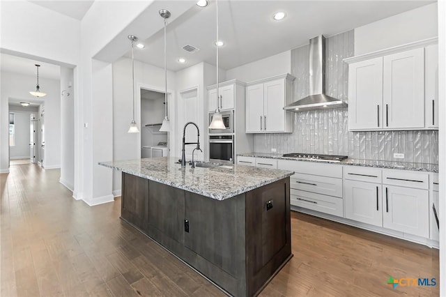 4201 Arques Ave, Round Rock, TX 78681 - kitchen with wall chimney range hood, a sink, backsplash, a kitchen island with sink, and white cabinetry