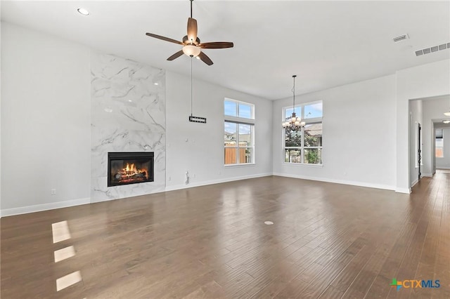 4201 Arques Ave, Round Rock, TX 78681 - unfurnished living room with a ceiling fan, a premium fireplace, dark wood-style flooring, a chandelier, and baseboards