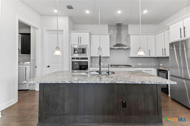 4201 Arques Ave, Round Rock, TX 78681 - kitchen with wall chimney range hood, stainless steel appliances, washing machine and clothes dryer, wine cooler, and white cabinets