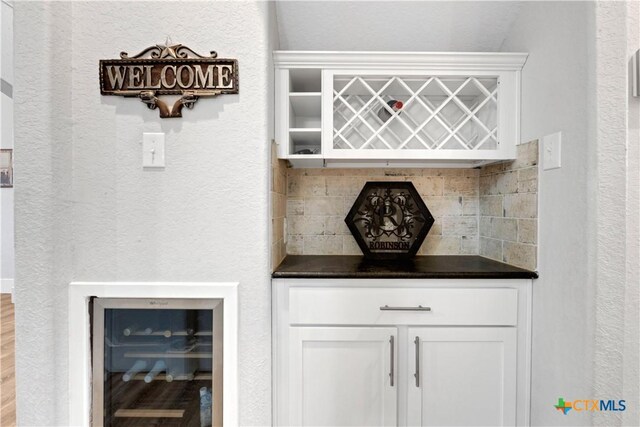 bar featuring tasteful backsplash, white cabinetry, and beverage cooler