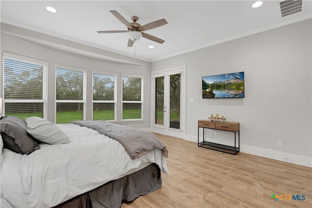 bedroom featuring crown molding, light hardwood / wood-style flooring, ceiling fan, access to exterior, and french doors