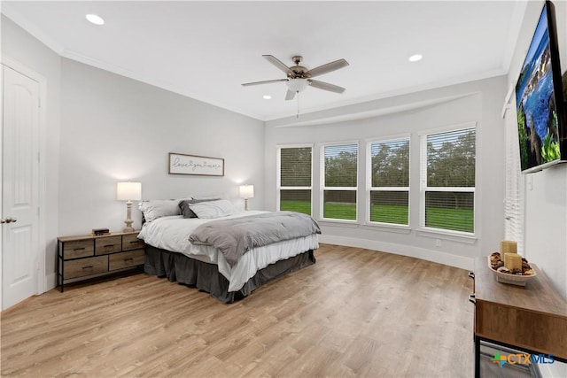 bedroom with ornamental molding, ceiling fan, and light hardwood / wood-style floors