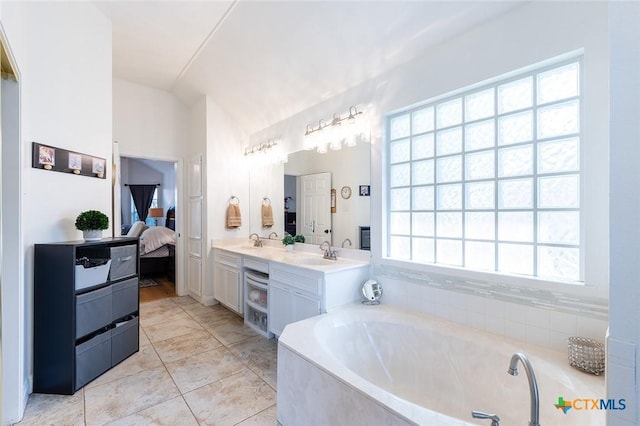 4010 Halfway Cv, Round Rock, TX 78681 - ensuite bathroom featuring a garden tub, ensuite bath, a sink, lofted ceiling, and double vanity