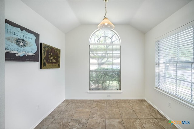 unfurnished room featuring tile patterned flooring and vaulted ceiling