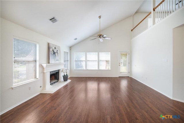 unfurnished living room with dark hardwood / wood-style flooring, a wealth of natural light, high vaulted ceiling, and ceiling fan