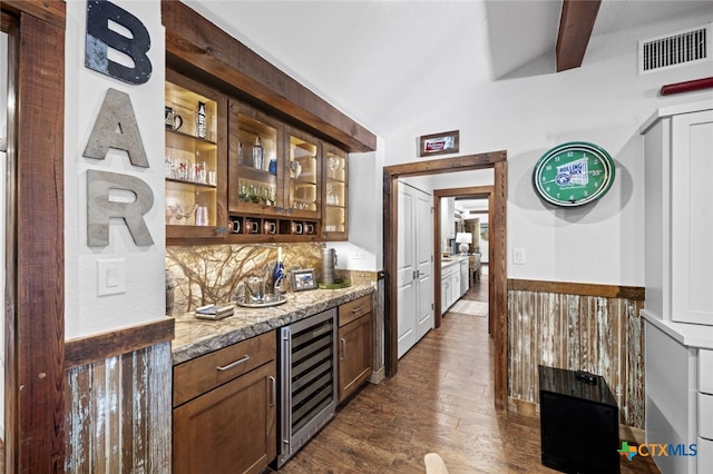 bar with visible vents, lofted ceiling with beams, dark wood-type flooring, wet bar, and beverage cooler