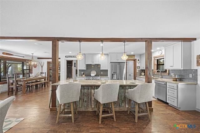 kitchen featuring appliances with stainless steel finishes, a breakfast bar, and dark wood-type flooring