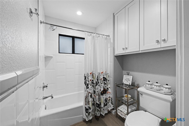 bathroom with toilet, wood finished floors, shower / tub combo with curtain, and a textured wall