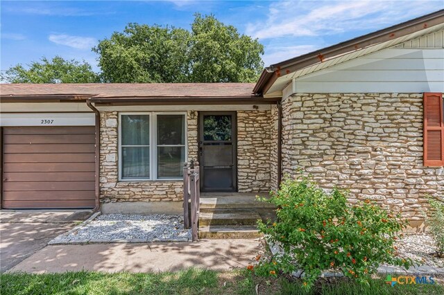 2307 Crescent Dr, Copperas Cove, TX 76522 - entrance to property featuring stone siding, a garage, and driveway