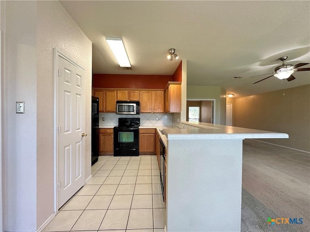 4609 Golden Gate Dr, Killeen, TX 76549 - kitchen with black appliances, a peninsula, light countertops, a ceiling fan, and brown cabinetry