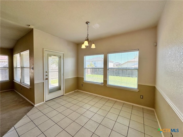 4609 Golden Gate Dr, Killeen, TX 76549 - unfurnished dining area with plenty of natural light, a chandelier, light tile patterned flooring, and a textured wall