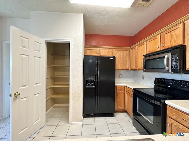 4609 Golden Gate Dr, Killeen, TX 76549 - kitchen featuring black appliances, light tile patterned floors, a textured ceiling, light countertops, and tasteful backsplash
