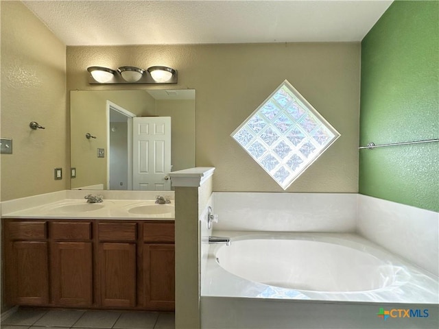 4609 Golden Gate Dr, Killeen, TX 76549 - bathroom featuring double vanity, a garden tub, tile patterned flooring, and a textured wall