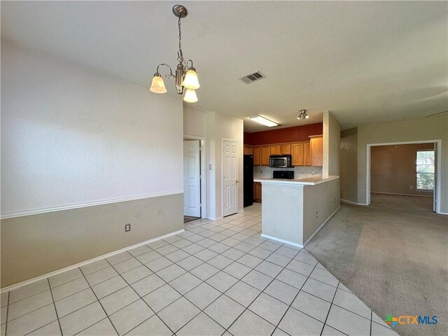 4609 Golden Gate Dr, Killeen, TX 76549 - kitchen with stainless steel microwave, light countertops, a chandelier, a peninsula, and light tile patterned floors