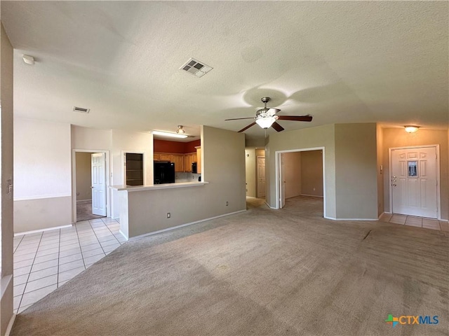 4609 Golden Gate Dr, Killeen, TX 76549 - unfurnished living room featuring a ceiling fan, light tile patterned floors, a textured ceiling, and light colored carpet
