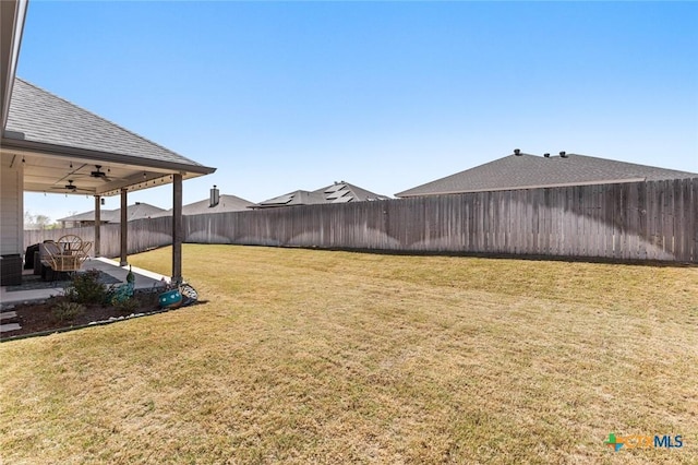 view of yard with a ceiling fan, a fenced backyard, and a patio area