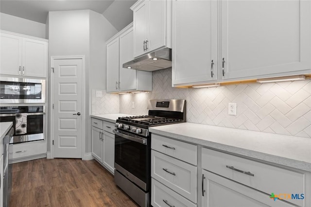 kitchen featuring light countertops, white cabinets, appliances with stainless steel finishes, under cabinet range hood, and dark wood-style floors