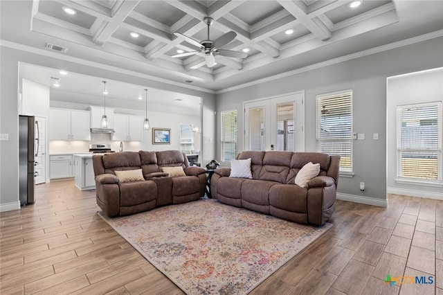 living area featuring visible vents, crown molding, ceiling fan, a towering ceiling, and wood finish floors