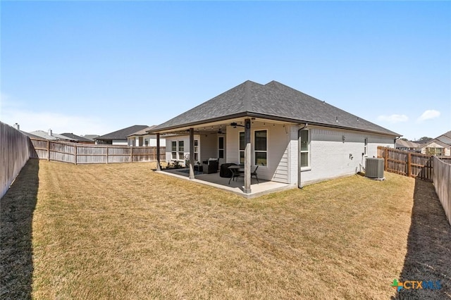 back of property with cooling unit, a fenced backyard, a ceiling fan, a yard, and a patio area